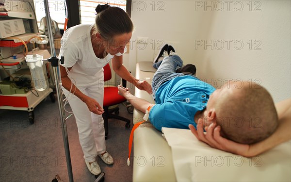 This internist in the centre of a larger city works mainly as a family doctor. The photo shows: A doctor's assistant putting in an infusion