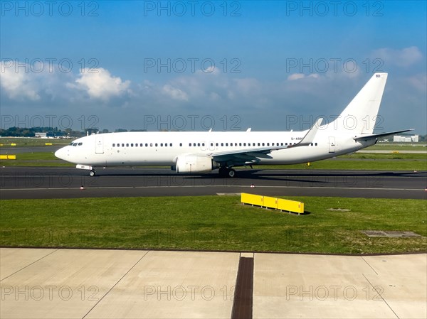 White painted aircraft without logo jet passenger aircraft Jet Boeing 737 86J D-ABBD year of construction 2002 in waiting position on taxiway taxiway in front of takeoff takeoff at Duesseldorf International Airport