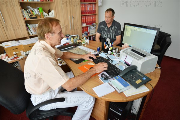 This internist in the centre of a larger city works mainly as a family doctor. The photo shows: Consulting a patient