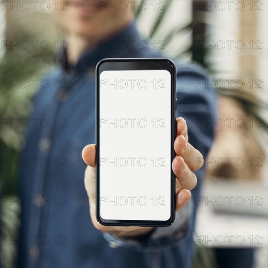 Businessman showing empty screen phone