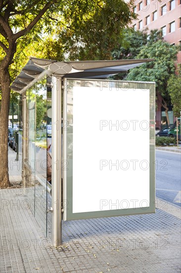 Billboard at bus stop with trees