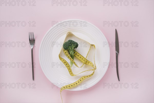 Broccoli and measurement tape on a dish