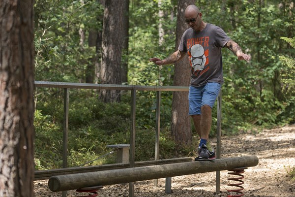 Man balancing on a beam on a trim trail