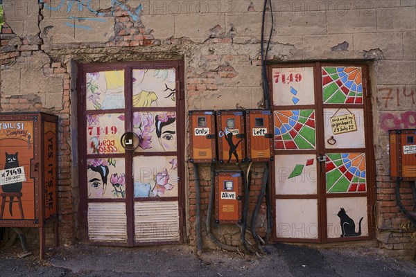 Electricity meters and cable distribution boxes decorated with graffiti on a street in the old town