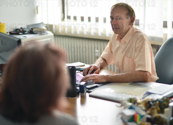 This internist in the centre of a larger city works mainly as a family doctor. The photo shows: Consulting a patient