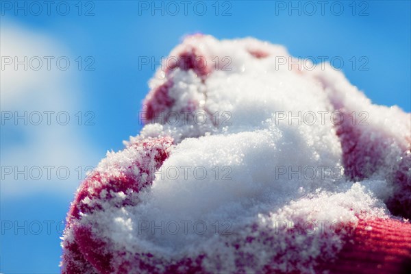 Heart of snow on the knitted red gloves
