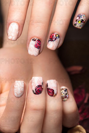 Beautiful manicure with flowers on female fingers. Nails design. Close-up. Picture taken in the studio on a white background