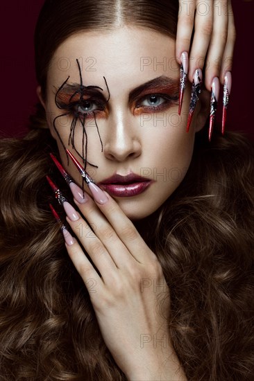 Portrait of woman in the image of spider with creative art makeup and long nails. Manicure design