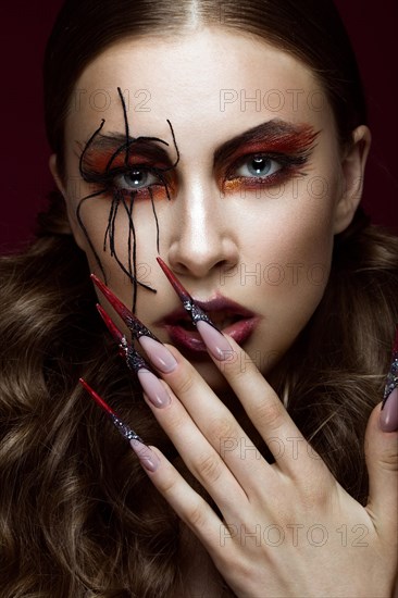 Portrait of woman in the image of spider with creative art makeup and long nails. Manicure design