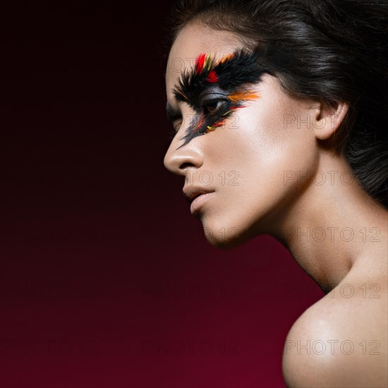 Beautiful girl in the image of the Phoenix bird with creative makeup .The beauty of the face. Photos shot in studio