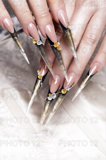 Long beautiful manicure with flowers on female fingers. Nails design. Close-up