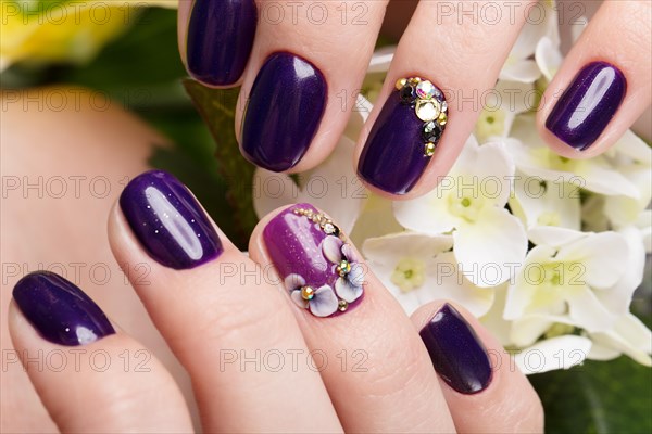 Shot beautiful manicure with flowers on female fingers. Nails design. Close-up. Picture taken in the studio on a white background