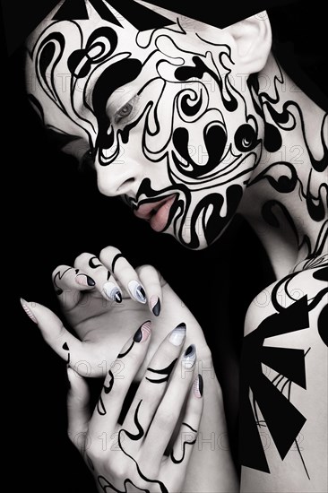 Beautiful girl with art black and white makeup and nails. Creative beauty face. Photo taken in the studio