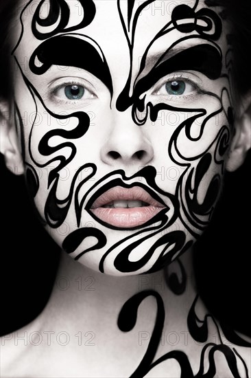 Beautiful girl with art black and white makeup and nails. Creative beauty face. Photo taken in the studio