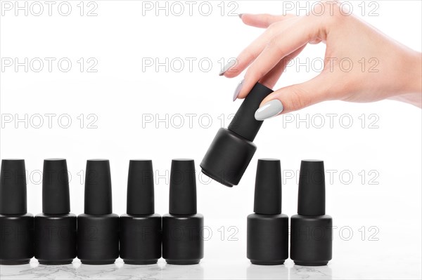 Black bottles of nail polish on a white background. Manicure design