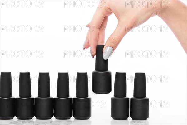 Black bottles of nail polish on a white background. Manicure design