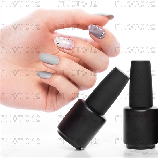 Black bottles of nail polish on a white background. Manicure design