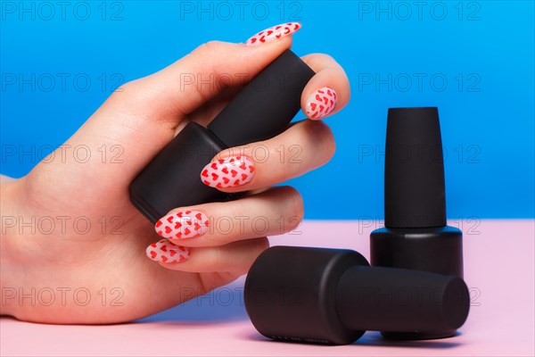 Black bottles of nail polish on a colorful background. Manicure design