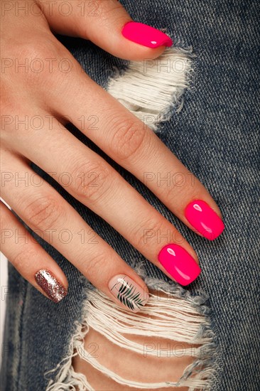 Bright neon manicure on female hands on the background of jeans. Nail design. Beauty hands