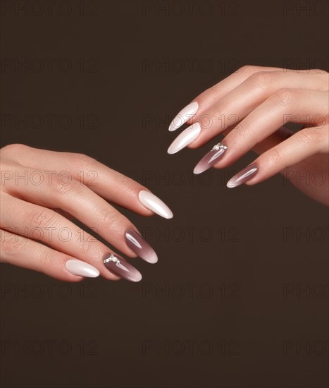 Beautiful classic manicure with crystals on female hand. Close-up. Picture taken in the studio