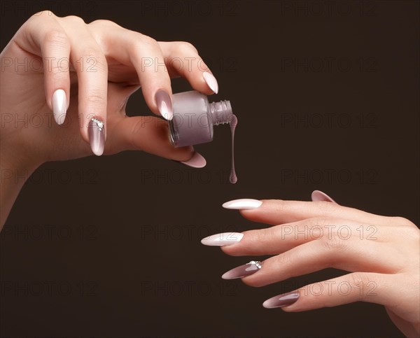 Beautiful classic manicure on female hand with nail polish. Close-up. Picture taken in the studio