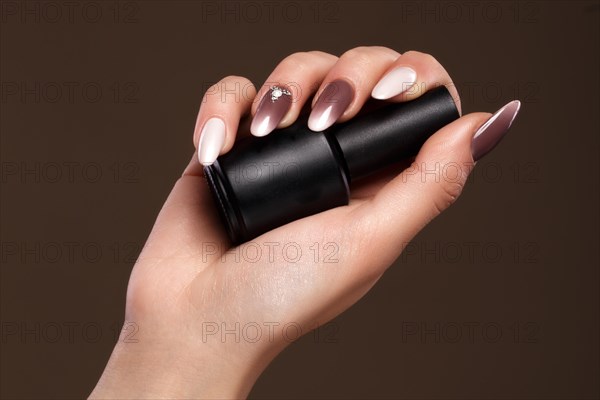 Beautiful classic manicure on female hand with nail polish. Close-up. Picture taken in the studio