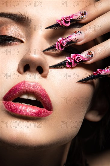 Beautiful girl with long nails and sensual lips. Portrait shot in the studio on a black background.Beauty face