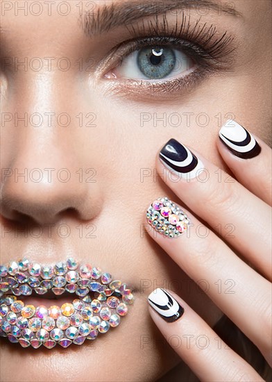 Beautiful girl with bright nails and lips of crystals