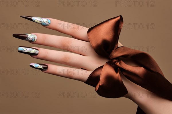 Creative design of nails on female hands. Art manicure. Photo taken in studio