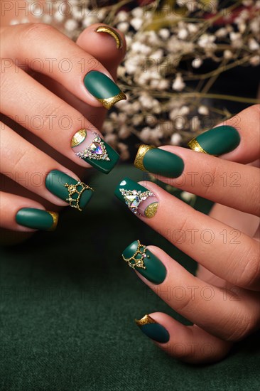 Creative green design of nails on female hands. Art manicure. Photo taken in studio
