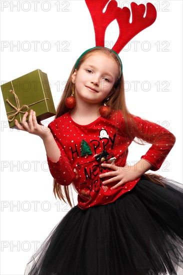 Beautiful little girl in a New Year's image with boxes of gifts in hands and deer horns on her head. Photo taken in the studio