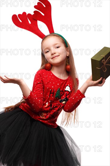 Beautiful little girl in a New Year's image with boxes of gifts in hands and deer horns on her head. Photo taken in the studio