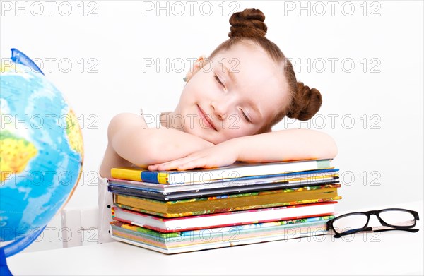 Little girl at the table of a first-grader. Photo taken in the studio