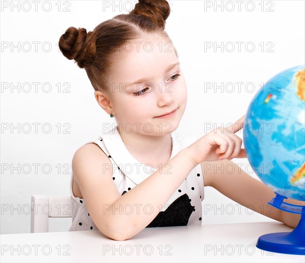 Little girl at the table of a first-grader. Photo taken in the studio