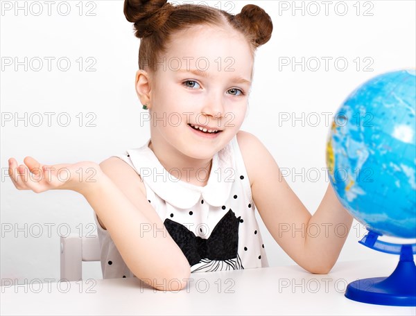 Little girl at the table of a first-grader. Photo taken in the studio