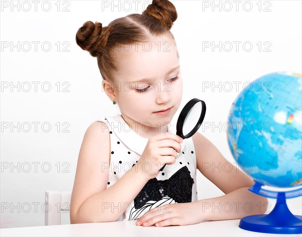 Little girl at the table of a first-grader. Photo taken in the studio