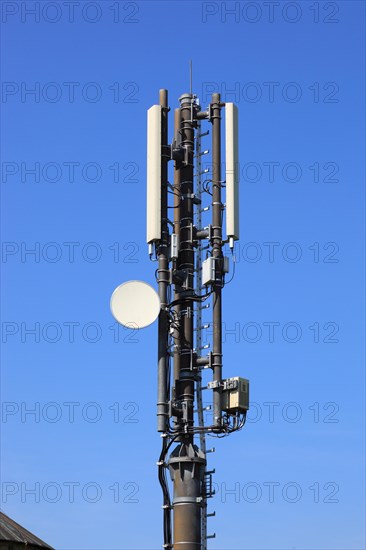 Transmission mast with directional radio antenna and antennas for mobile phone reception