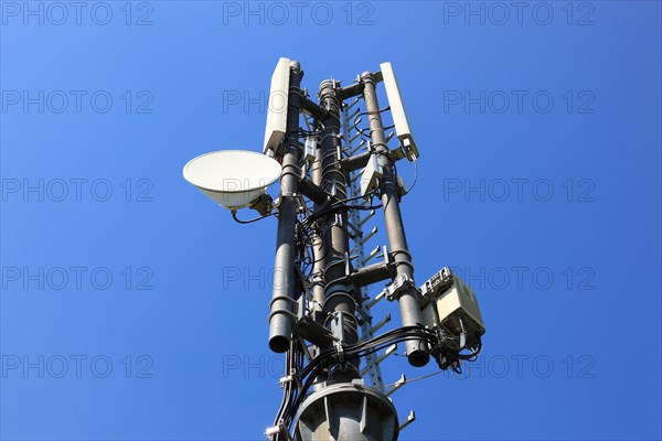 Transmission mast with directional radio antenna and antennas for mobile phone reception