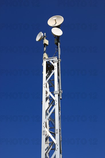 Transmission mast with directional radio antenna and antennas for mobile phone reception