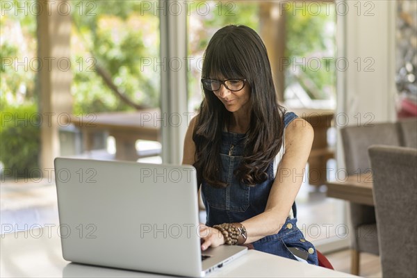 Business woman working from home while looking at laptop