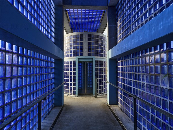 Access to the S-Bahn platform with lift made of blue glass blocks and exposed concrete