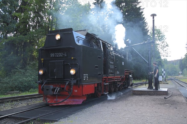 Steam locomotive refuelling water at the water crane