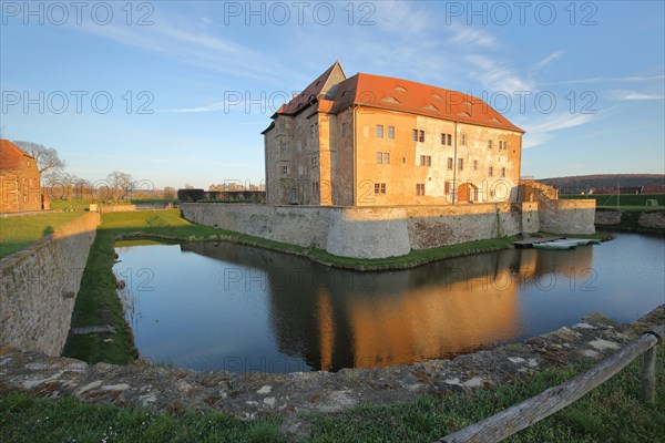 Renaissance moated castle with reflection in the pond