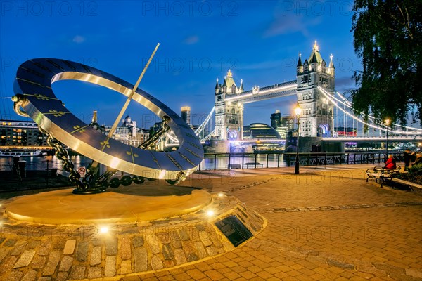 Sundial in front of Tower Bridge over the Thames at dusk