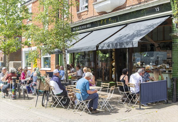 People sitting on street outside cafe