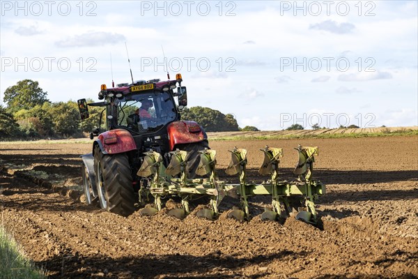 CASE 220 red tractor ploughing field six-furrow plough