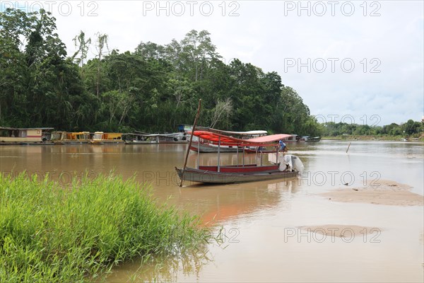 Fishing boats and transport boats on the Jordao River in the Amazon rainforest
