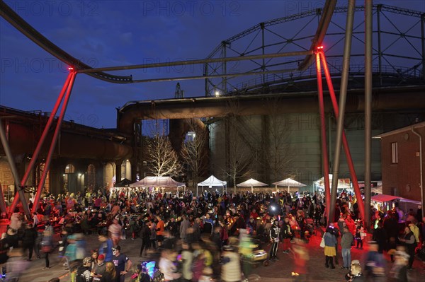 Crowds of people against a nocturnal industrial backdrop