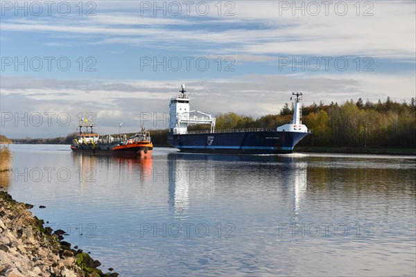 Cargo ship overtakes suction dredger in Kiel Canal