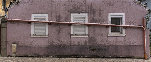 Drain pipe runs across the windows of a single-family house